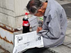 Lendo o jornal na rua